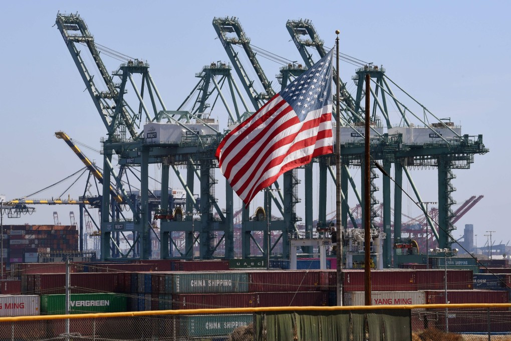 The US flag flies over Chinese shipping containers that were unloaded at the Port of Long Beach, in Los Angeles County. Tit-for-tat tariffs in the escalating trade war have battered global confidence for more than a year. Photo: AFP