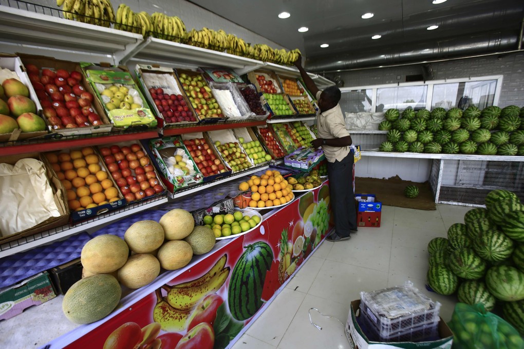 A fruit seller organises fresh produce at a shop in the Sudanese city of Omdurman. Many countries, in particular in Africa, rely on bananas for over a quarter of their daily calorie intake. Photo: AFP