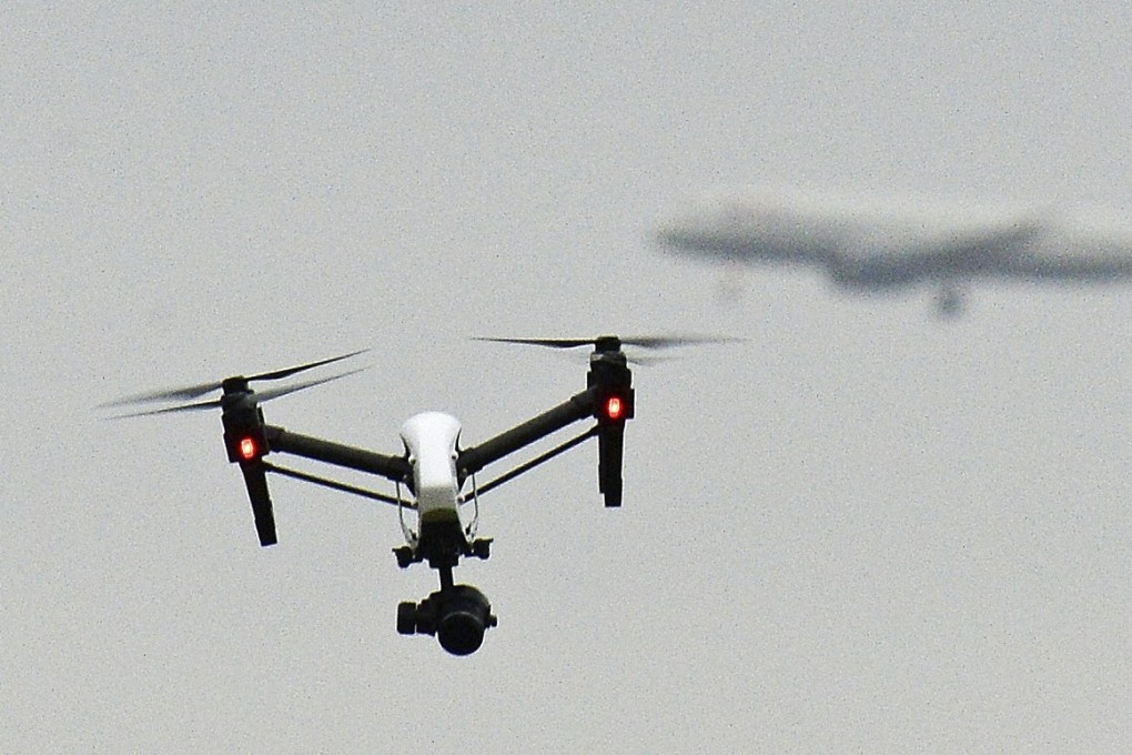 A drone flies in the foreground as a plane prepares to land at Heathrow Airport. Photo: AP
