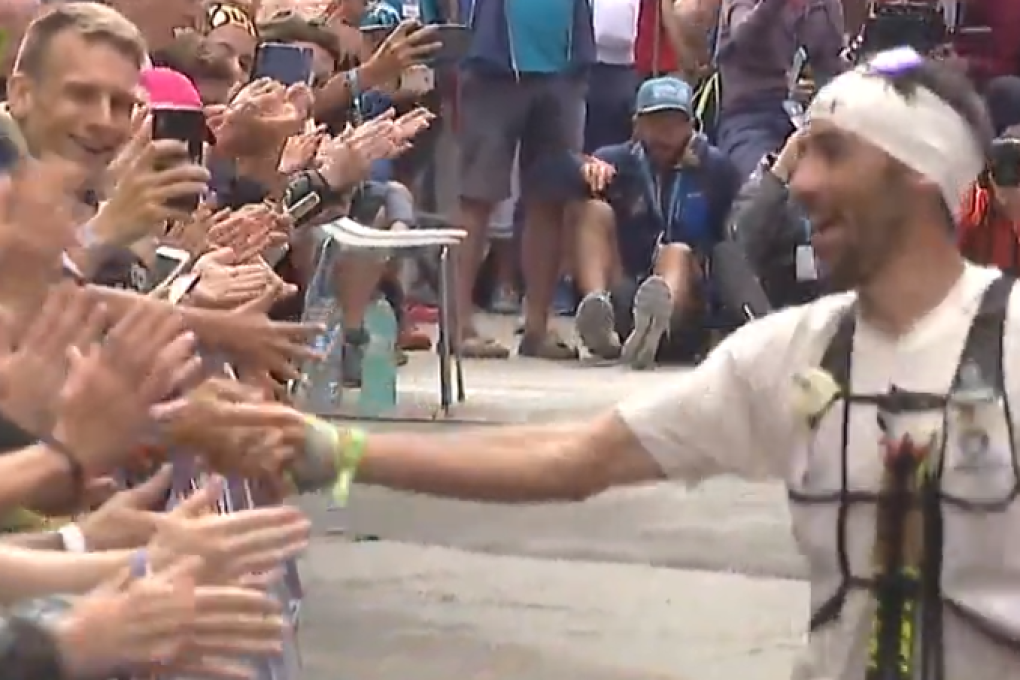Winner of the CCC, UTMB, Luis Alberto Hernando Alzaga, high fives the crowd. Photo: UTMB TV