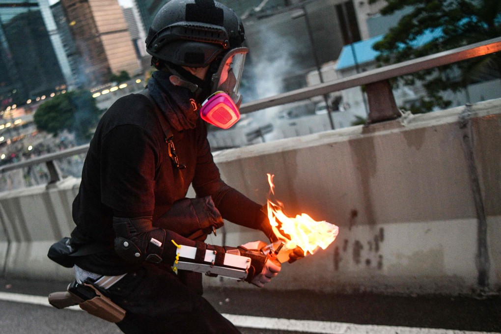 A protester throws a petrol bomb towards police outside government headquarters on Saturday. Photo: AFP