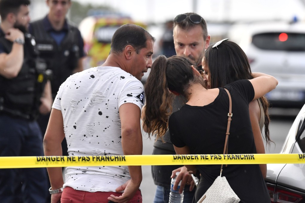 A witness is comforted by friends in Villeurbanne, southeastern France. Photo: AFP