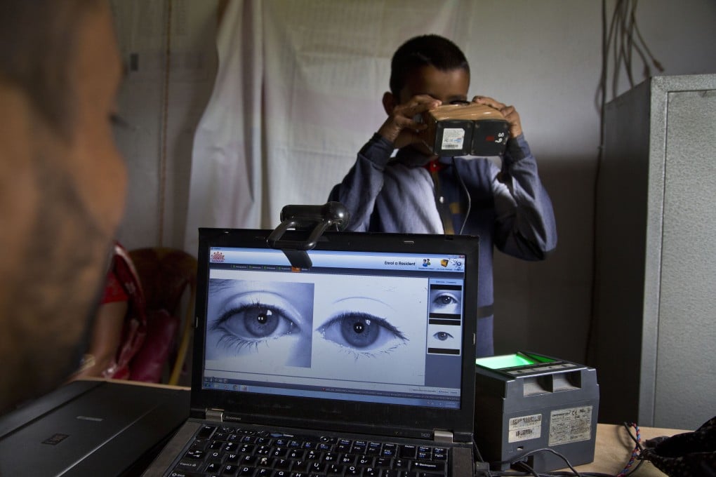 A National Register of Citizens officer takes a photograph of the eyes of a boy at an NRC centre in Gauhati. Photo: AP