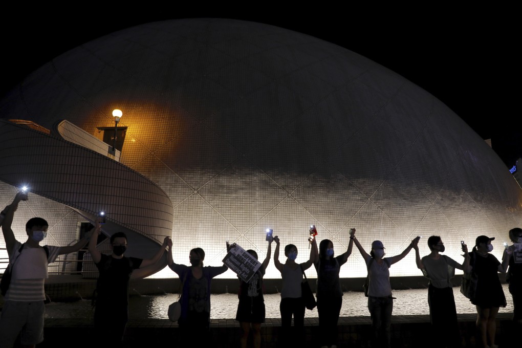 Demonstrators link hands as they gather at the Hong Kong Space Museum in Tsim Sha Tsui on August 23. At least 210,000 people joined human chains on both sides of Victoria Harbour on the day, in a gesture of support for the demands of Hong Kong protesters. Photo: AP