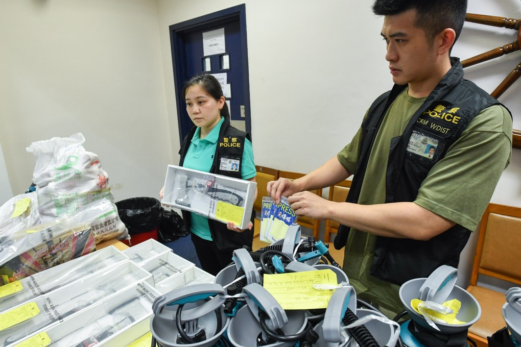 Police show press badges and various other gear confiscated from National Disaster Hardware Shop’s Sai Ying Pun storefront. Photo: Handout