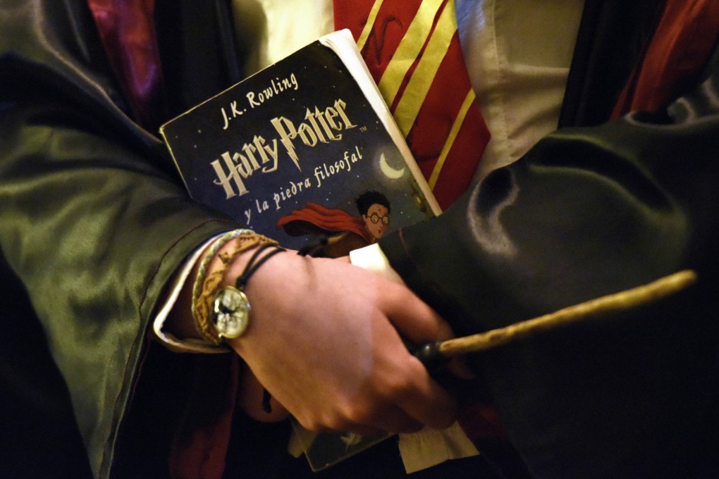 A Harry Potter fan holds a copy of Harry Potter and the Philosopher's Stone during an event to mark the 20th anniversary of the publication. Photo: Xinhua