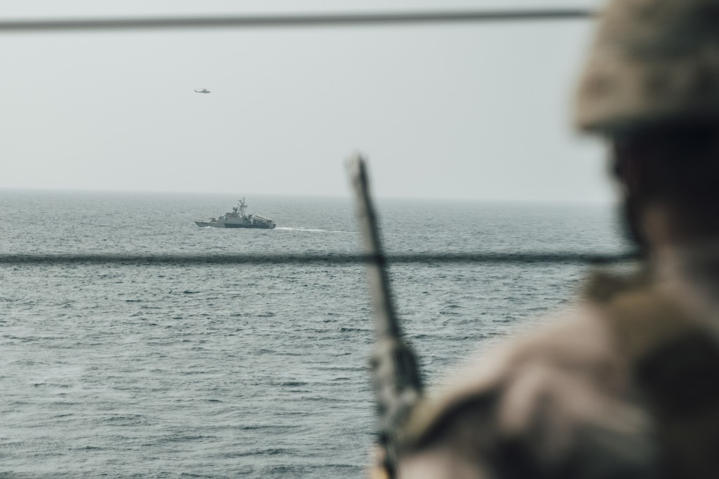 A US marine observes an Iranian fast attack craft in the Strait of Hormuz. Photo: EPA