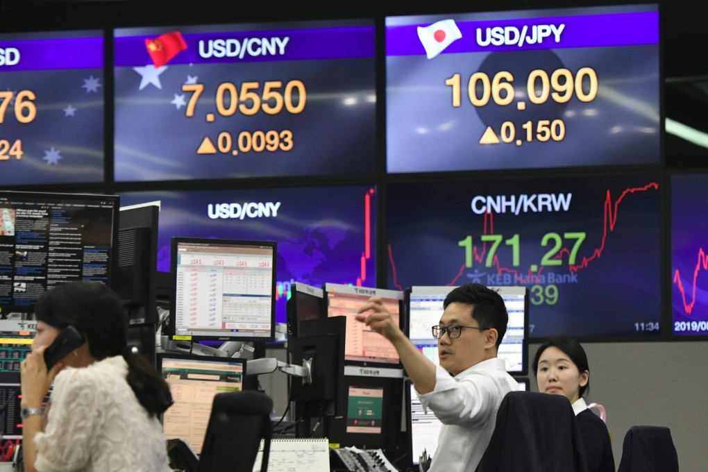 Currency dealers monitor exchange rates in a trading room at a bank in Seoul on August 6. The day before, the US officially labelled China a currency manipulator amid a worsening trade war, after Beijing let the yuan tumble past the seven-per-dollar level for the first time since 2008. Photo: AFP