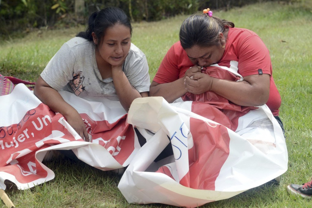 Relatives of mayoral candidate Karina Garcia, who was killed in southern Colombia, cry as they embrace one of her political banners. Photo: El País de Cali via AP