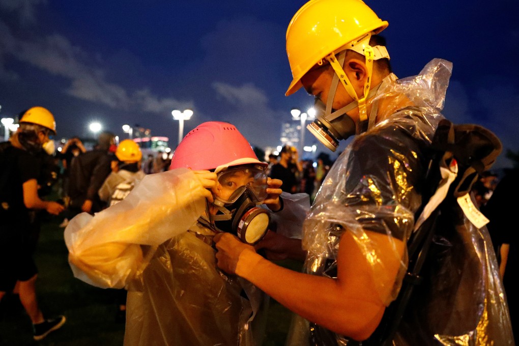 A young protester helps his girlfriend during a rally outside the government headquarters in Hong Kong. Photo: Reuters