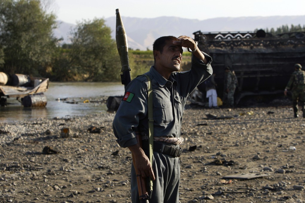 Afghan police inspect the site where fuel tankers hijacked by the Taliban were bombed outside Kunduz in 2009. Photo: AP