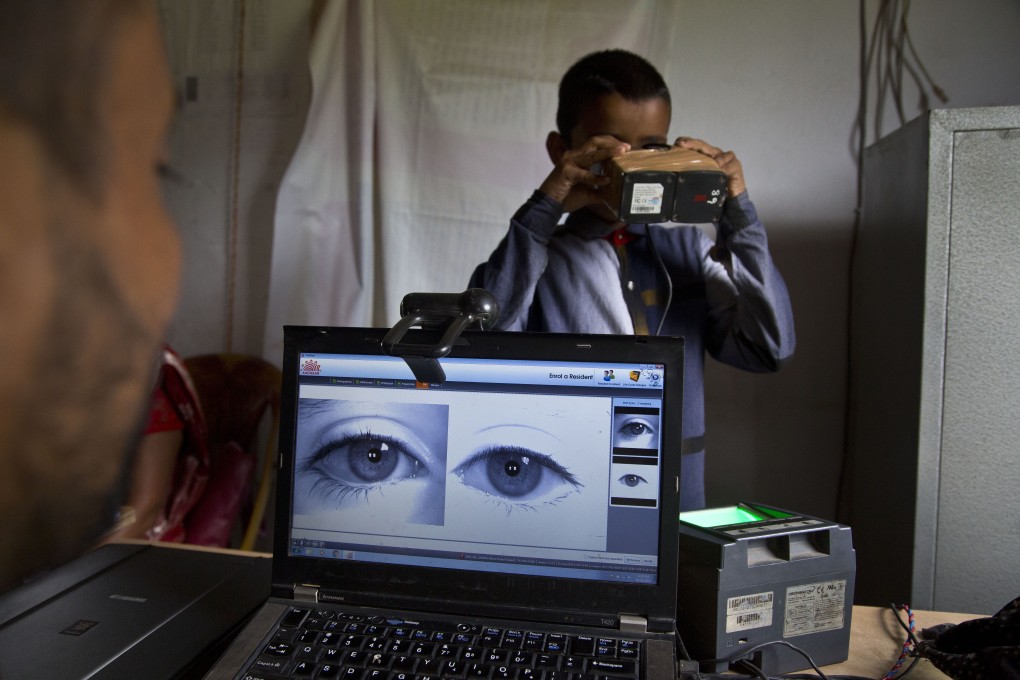 An officer takes a photograph of the eyes of a boy on the eve of the release of a citizenship list in India, after decades of complaints about illegal immigrants from Bangladesh. Photo: AP