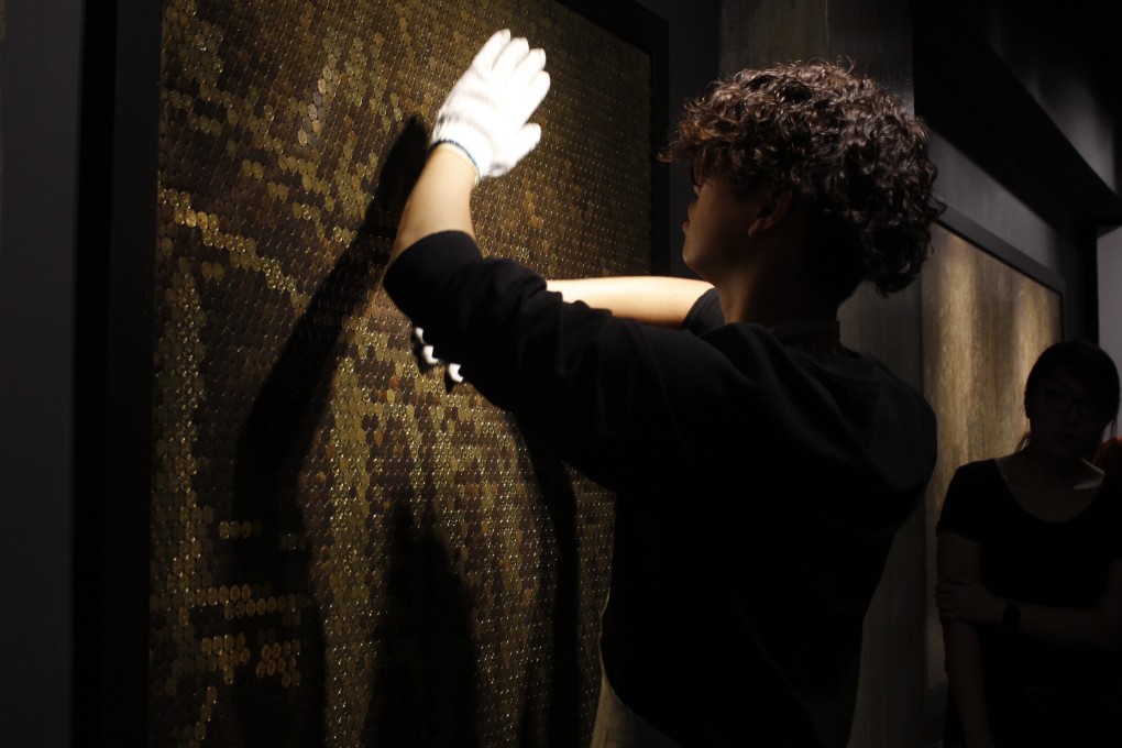 Giraffe Leung rubs a panel made of 20-cent coins with chemical solutions to create an image of Hong Kong at La Galerie Paris 1839 in Central. Photo: Snow Xia