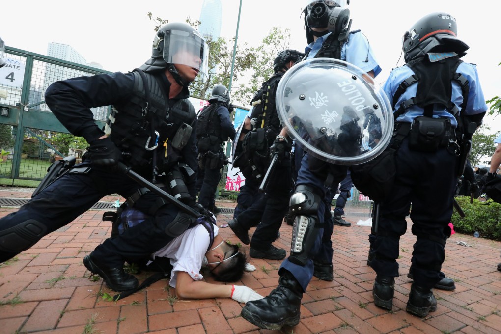 Police in riot gear restrain a protester outside the Legislative Council building in June. Photo: Felix Wong