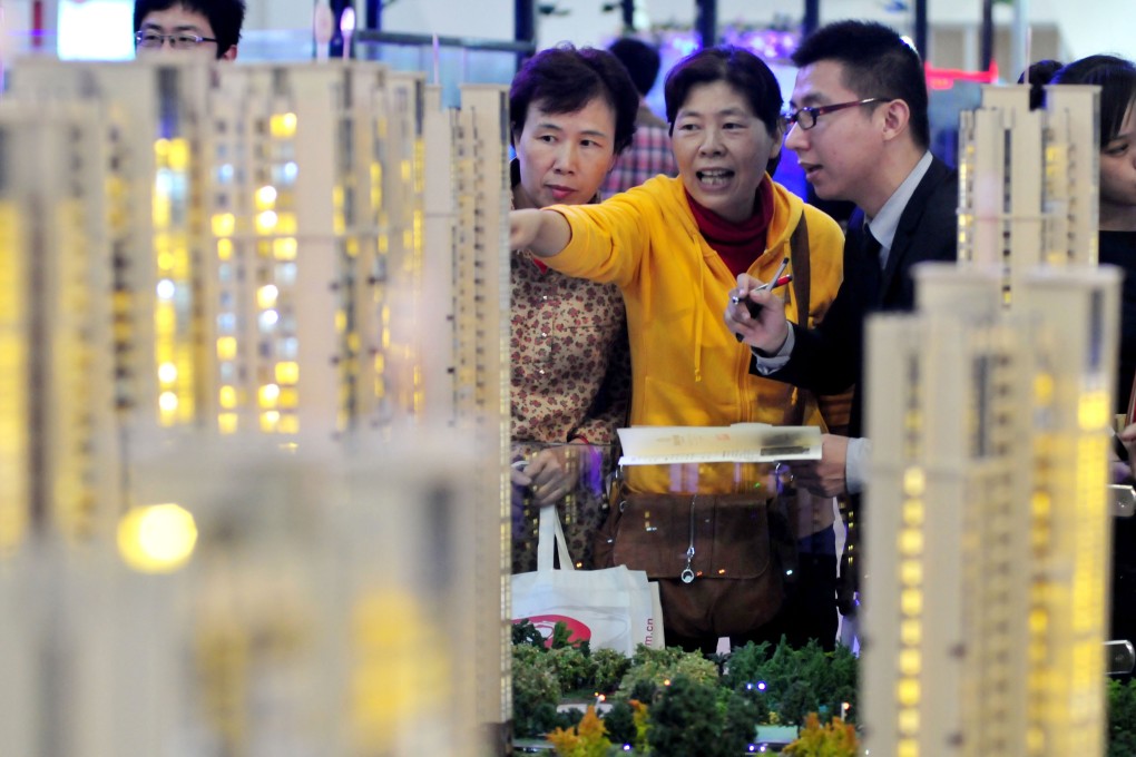Visitors looking at building models at a real estate and home decorations expo in Fuzhou, capital of southeast China's Fujian province on November 16, 2012. Photo: Xinhua