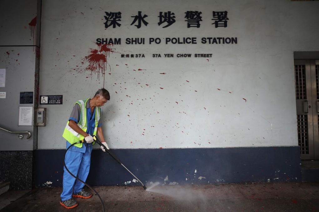A worker cleans up the outside of Sham Shui Po Police Station after anti-government clashes. Photo: Winson Wong