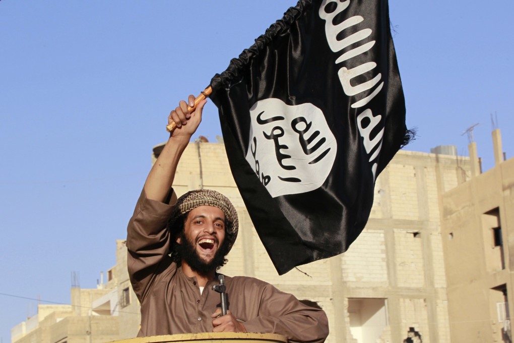 A militant Islamist fighter waves the flag of Islamic State in Syria's Raqqa province in 2014. Photo: Reuters