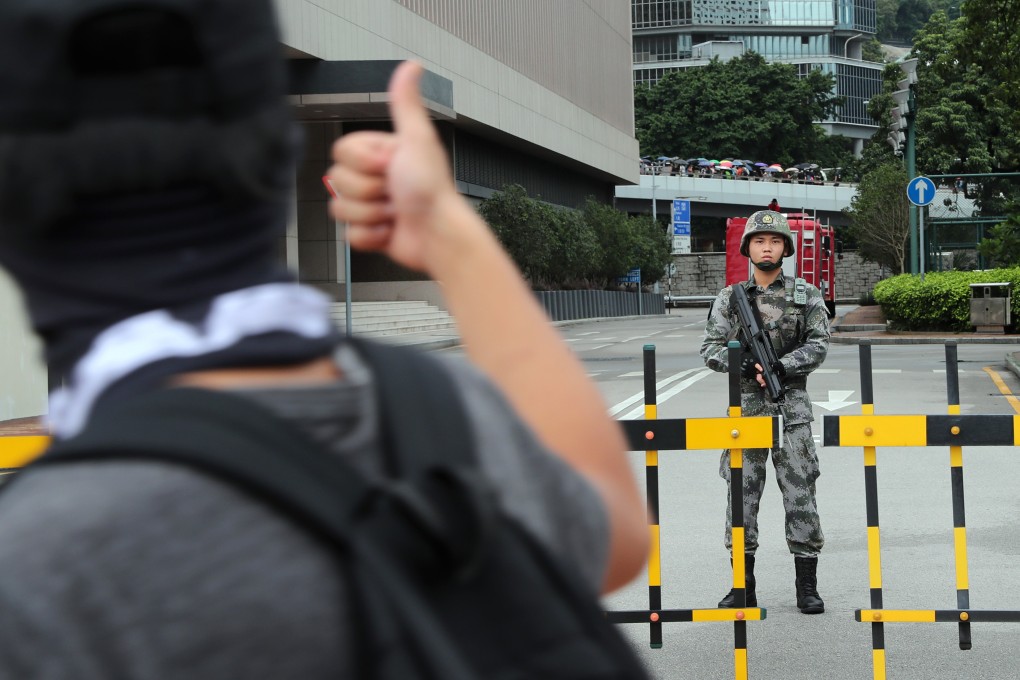 A protester gives a thumbs up to a soldier from the People’s Liberation Army outside its building in Tamar, Admiralty, on August 31. Photo: Sam Tsang