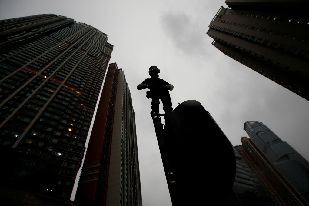 A demonstrator stands on top of a traffic light during a protest on August 25. Most people do not willingly spend their precious weekends at political rallies. They are stirred to take political action when life becomes so bad they feel they have no choice. Photo: Reuters