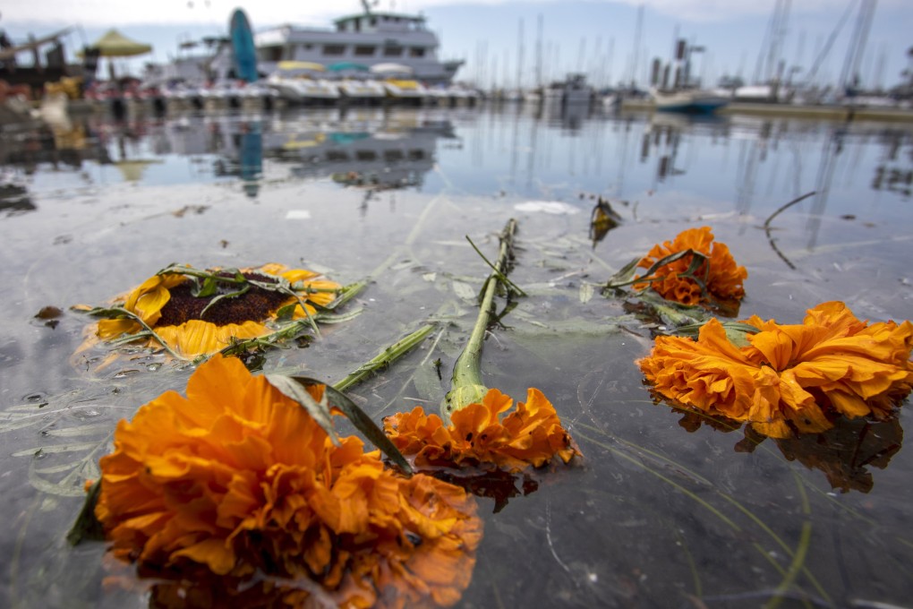 Flowers memorialising the victims of the fire float in the water near the docks of Truth Aquatics, owner of the dive boat Conception. Photo: EPA
