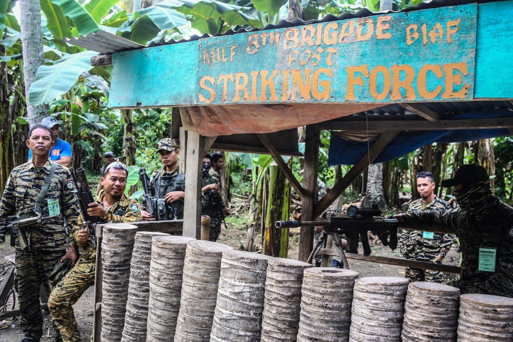 Moro Islamic Liberation Front (MILF) rebels stand guard ahead of a weapons decommissioning ceremony. Photo: AFP
