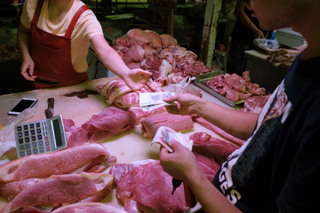 A Chinese vendor serves a customer at her pork stall in Beijing. Photo: EPA-EFE