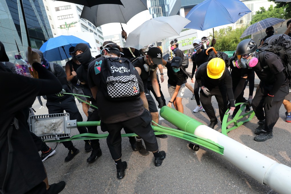 Anti-government protestors disassemble a smart lamp post near the Zero Carbon Building, Kowloon Bay, on August 24. Photo: Dickson Lee