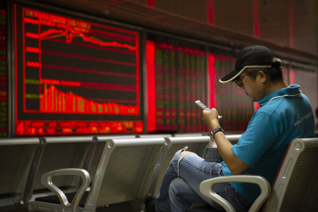 A Chinese investor uses his smartphone as he monitors stock prices at a brokerage house in Beijing on August 20, 2019. Photo: Associated Press