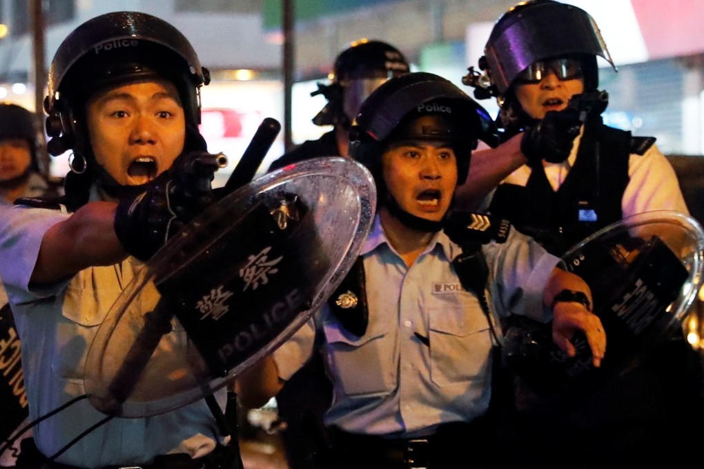 Police officers point guns at anti-government protesters in Tsuen Wan on August 25. Photo: Reuters