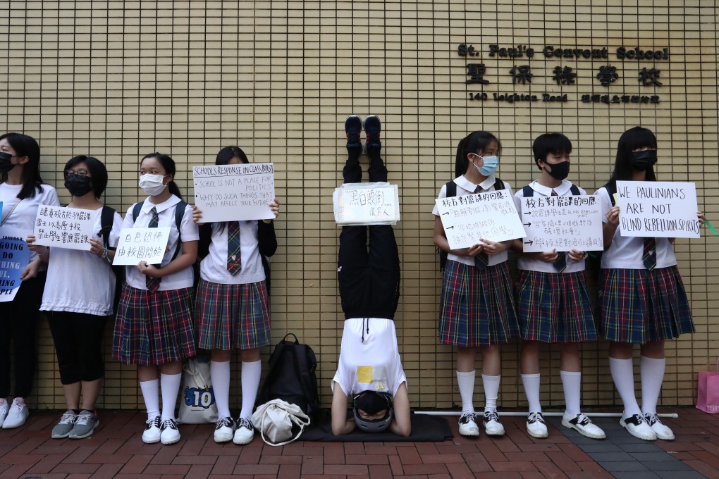 A student in a headstand carries a sign saying: It’s exhausting when everything is topsy turvy. Alumni and students formed a human chain on September 6, calling for Chief Executive Carrie Lam to meet all five protest demands, at St Paul's Convent School in Causeway Bay, Hong Kong. Photo: Jonathan Wong