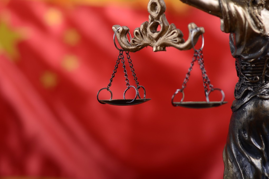 The Scales of Justice and Lady Justice in front of China’s national flag. Photo: Alamy