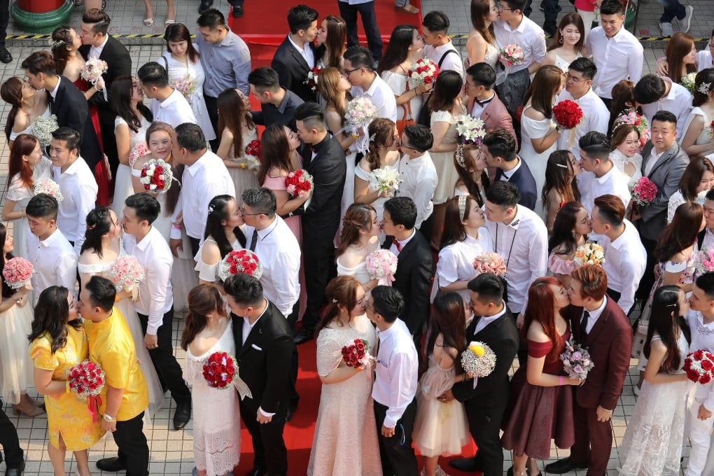 Newlywed couples kiss during the mass wedding in Kuala Lumpur on Monday. Photo: Reuters