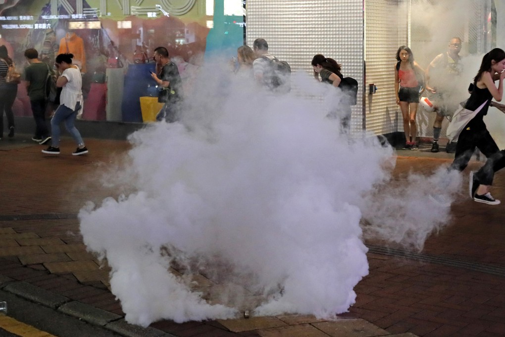 People run as police fire tear gas in Hong Kong on Sunday. Photo: AP