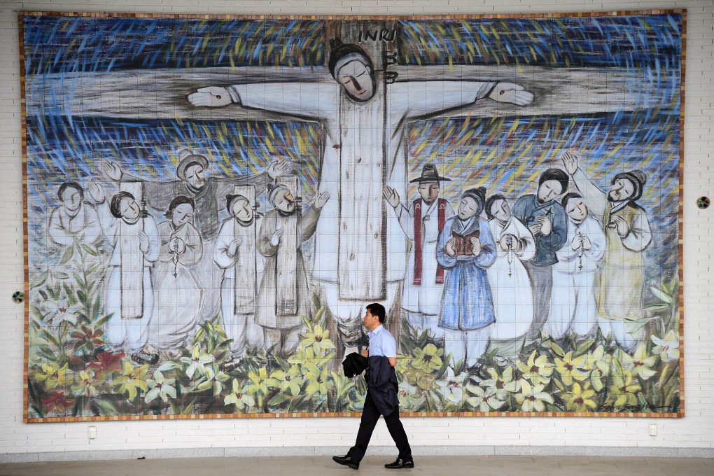 A man passes in front of a huge wall painting for South Korea’s Catholic martyrs at Solmoe Shrine in Dangjin, 85km southwest of Seoul. Photo: AFP