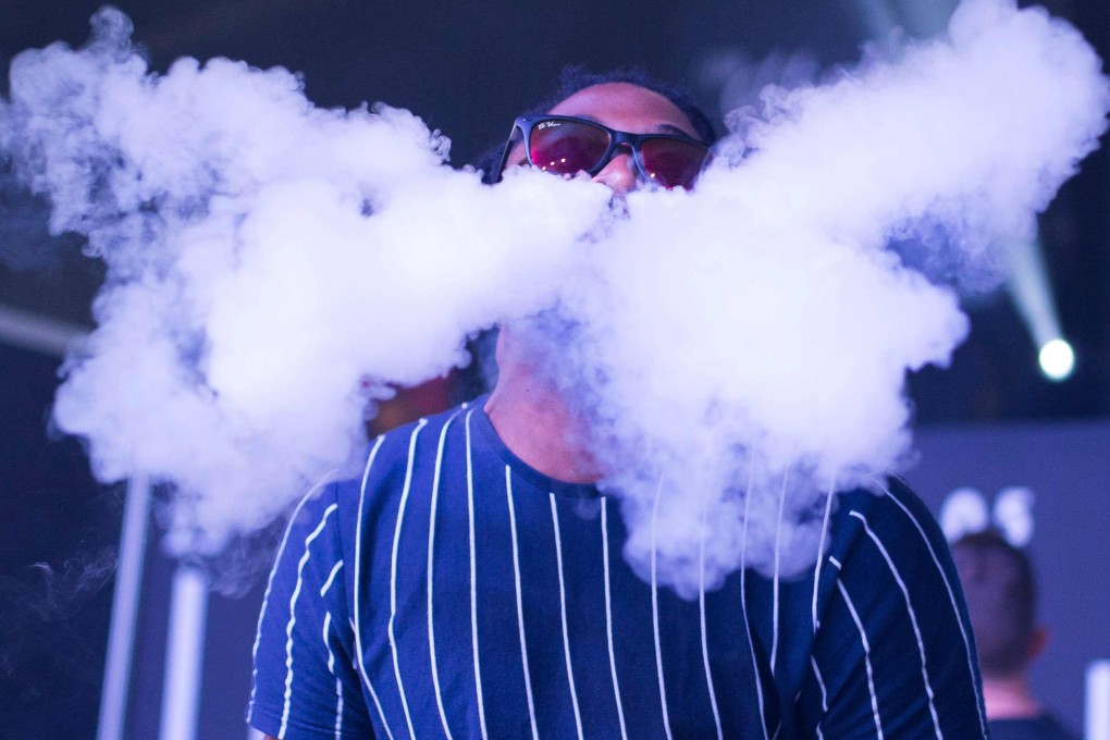 A man blows smoke from an electronic cigarettes as he takes part in a vaping trick competition during VapeCon in Pretoria, South Africa. Photo: AFP