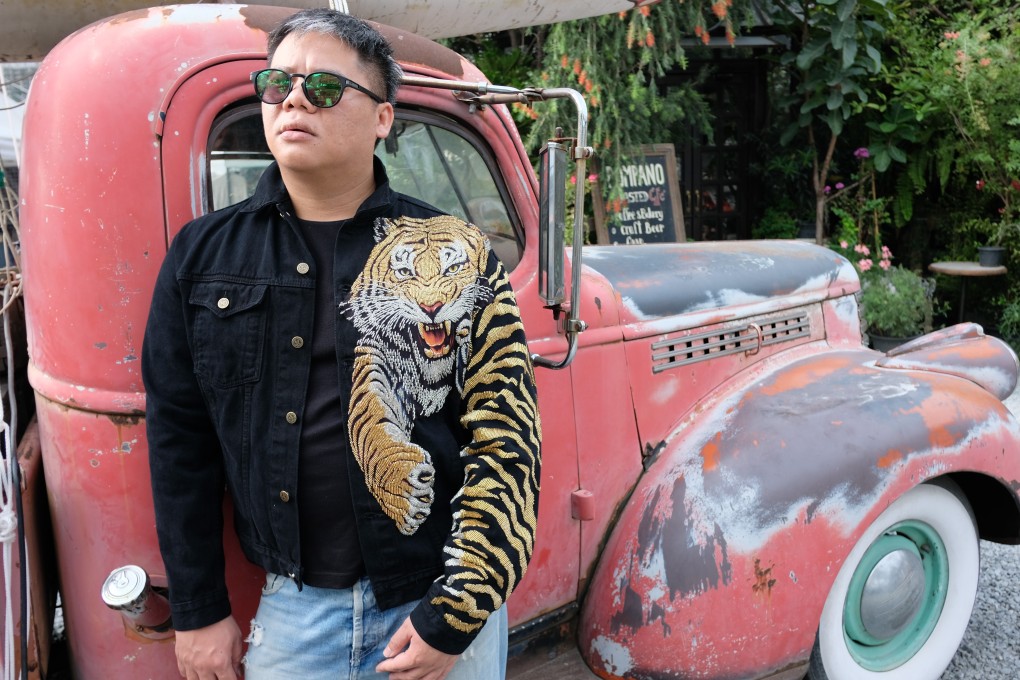 Thai fashion designer Santichai Srisongkram wears his label’s “Thaiger-Man” jacket at a retro outdoor market in Bangkok, Thailand. He has had orders for customised versions of the jacket from as far away as Colombia. Photo: Photo: Tibor Krausz
