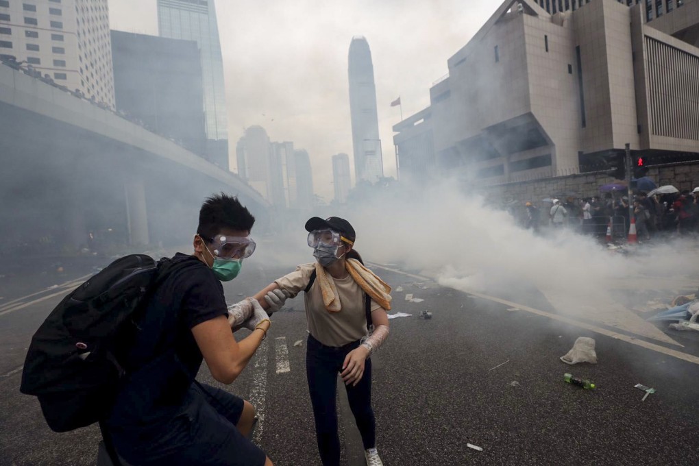 Two protesters run from a cloud of tear gas on Harcourt Road in Admiralty during clashes with police on June 12. Photo: Sam Tsang