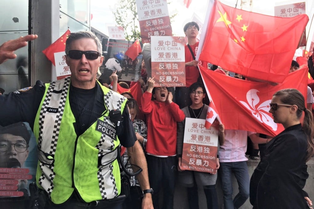 Pro-China protesters rally outside Vancouver’s Broadway subway station on August 17. They were facing a rival crowd supporting the Hong Kong protest movement, with police keeping the rival camps separated. Photo: Kevin Huang