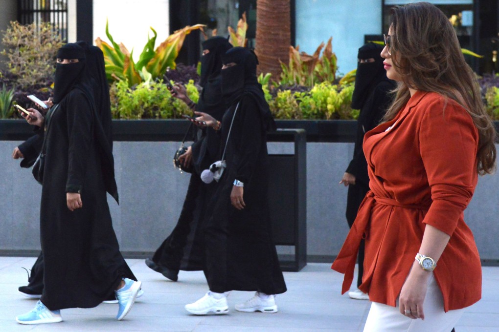 Mashael al-Jaloud, 33, walks in western clothes past women wearing niqab. Photo: AFP