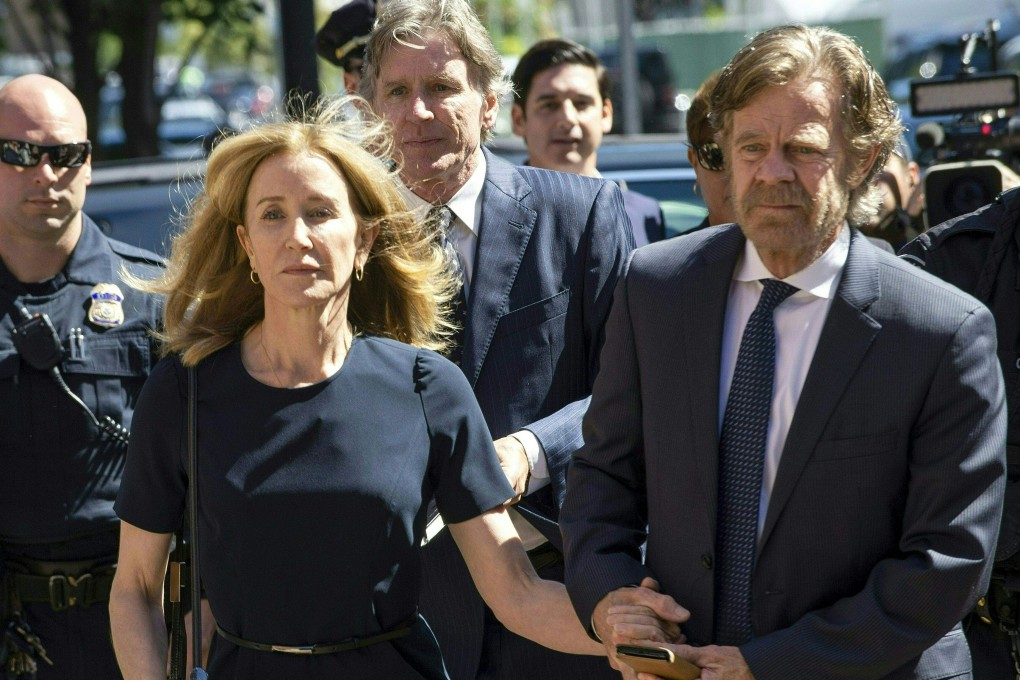 Actress Felicity Huffman, escorted by husband William H. Macy, makes her way to the courthouse entrance in Boston on Friday. Photo: AFP