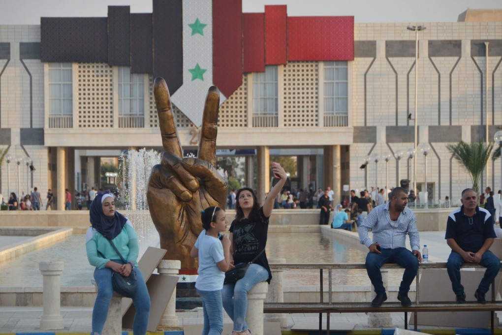 People attend the Damascus Fair in the Syrian capital. Louvre Hotels Group, owned by China’s Jin Jiang, has signed an agreement to open two hotels under its own name there. Photo: AFP