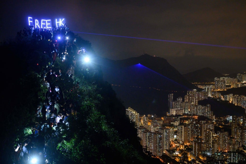 People hold up LED-lit letters spelling “Free HK” on Lion Rock in Hong Kong on September 13. Photo: AFP