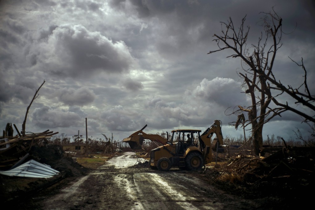 Mos Antenor, 42, drives a bulldozer while clearing the road after Hurricane Dorian Mclean's Town, Grand Bahama. Photo: AP Photo
