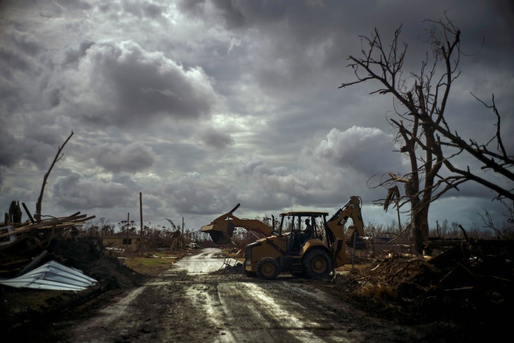 Mos Antenor, 42, drives a bulldozer while clearing the road after Hurricane Dorian Mclean's Town, Grand Bahama. Photo: AP Photo