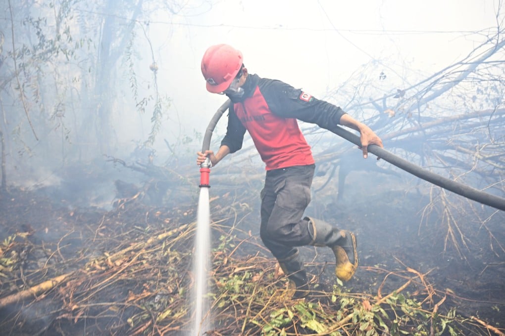 A firefighter works to put out a blaze in Kampar on Monday. Photo: AFP