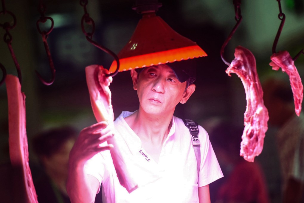 A customer checks out pork meatat a market in Hangzhou, China. Photo: AFP
