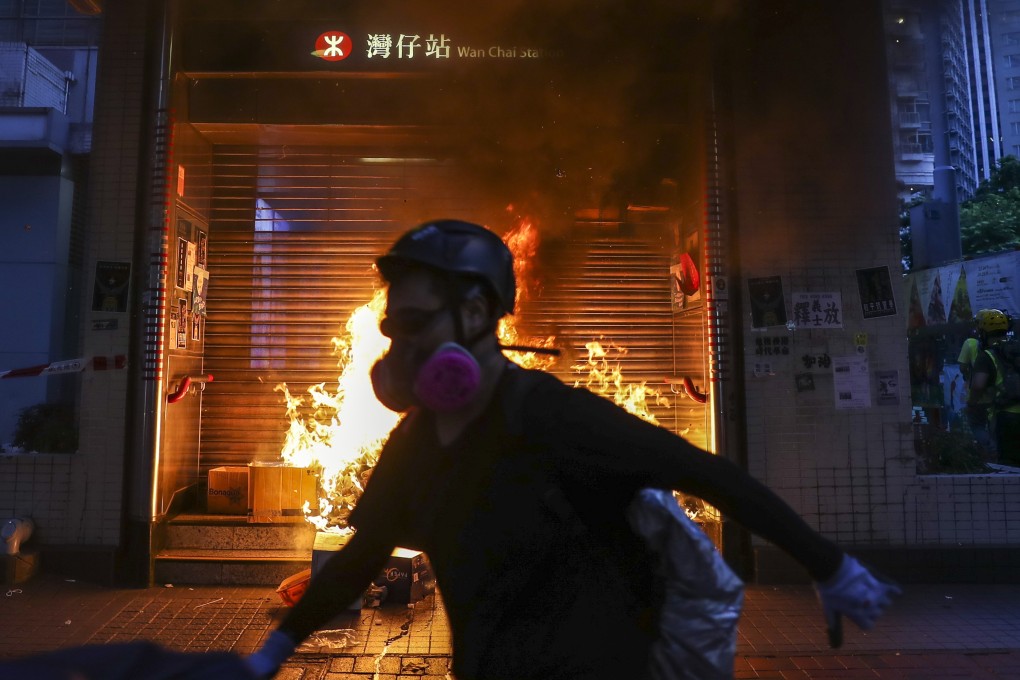 Protesters start a fire at an entrance to Wan Chai MTR station on Sunday night, but train services had resumed on Monday morning. Photo: Sam Tsang