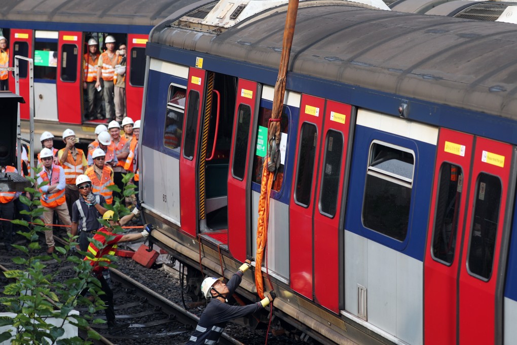 MTR engineer staff try to lift a train carriage back onto the track after it was derailed at Hung Hom station on Tuesday morning. Photo: Sam Tsang
