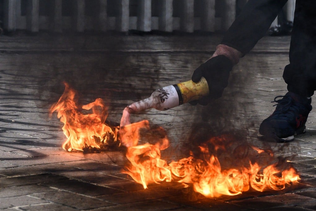 A protester lights a petrol bomb before throwing it at police stationed outside government headquarters in Hong Kong on Sunday. Photo: AFP
