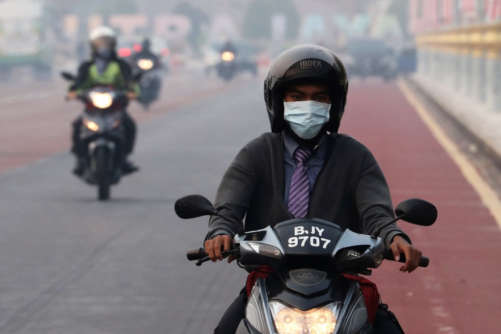 A man rides on a motorcycle in the haze in Putrajaya, Malaysia. Photo: Reuters